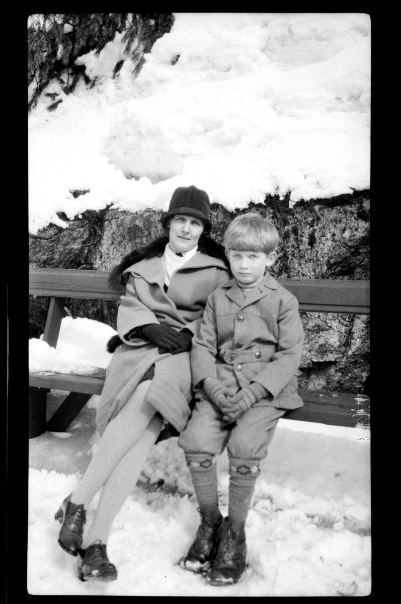 Rolf Sr. Sundt, Mor og sønn, Hilda og Rolf Sundt Jr., på en benk i snøen. Fotografert 1928.