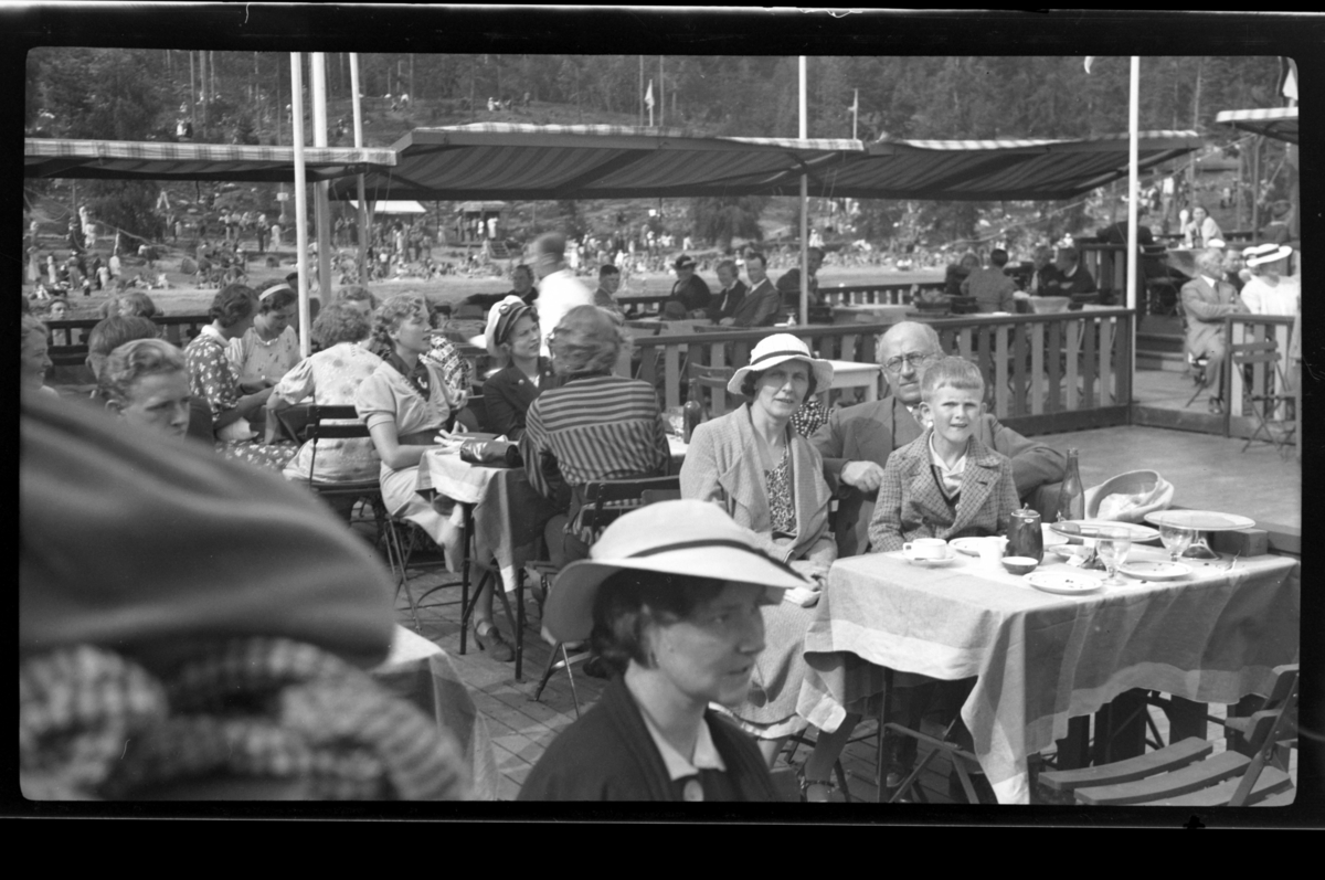 Rolf Sr. Sundt, Hilda og Rolf Sundt sr. sitter sammen med sin sønn Lars Peter ved et bord på Hvalstrand restaurant. Fotografert 1936.
