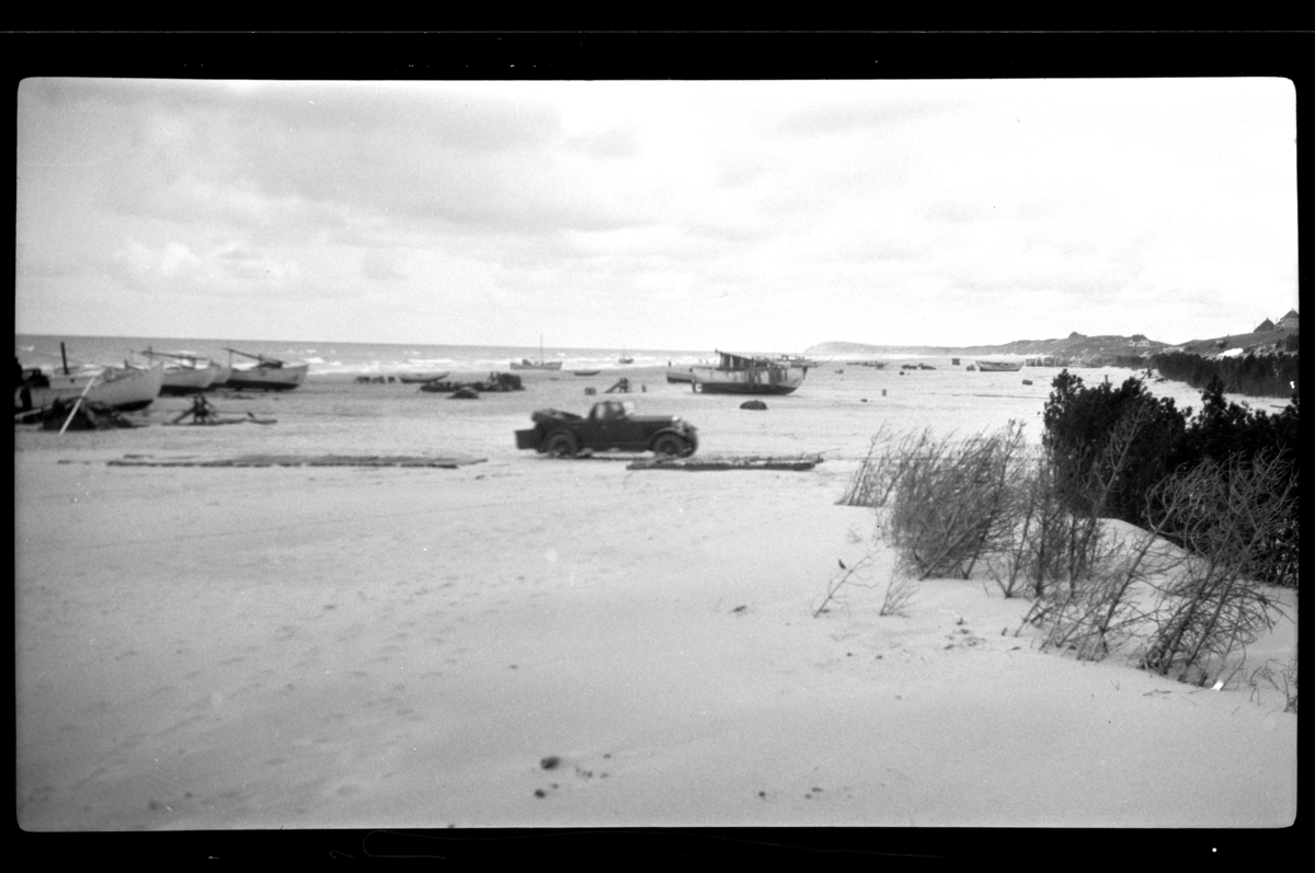 Rolf Sr. Sundt, Rolf Sundt sr.'s Buick står på en strand sammen med mange båter som ligger på land i Skagen. Fotografert 1927.