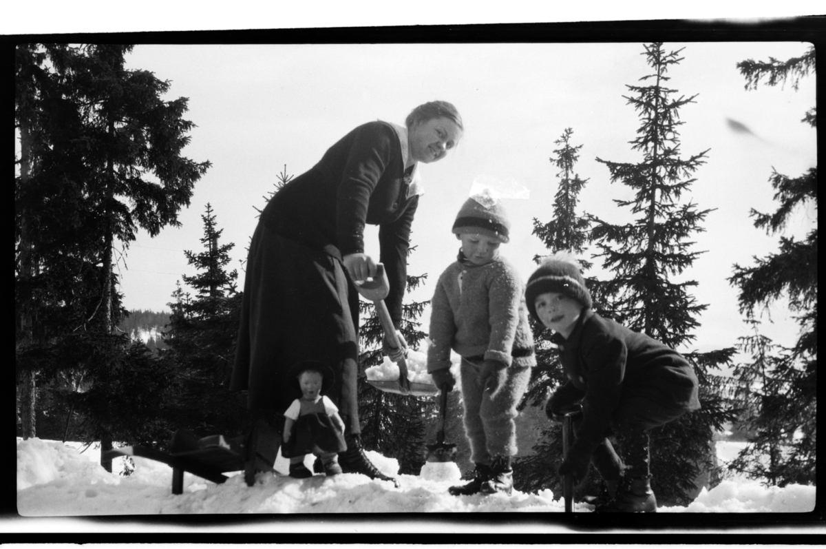 Rolf Sr. Sundt, Julius Sundt og Didrik Zernichow leker sammen med en ukjent dame i snøen, Villa Knyggen. Fotografert 1920.