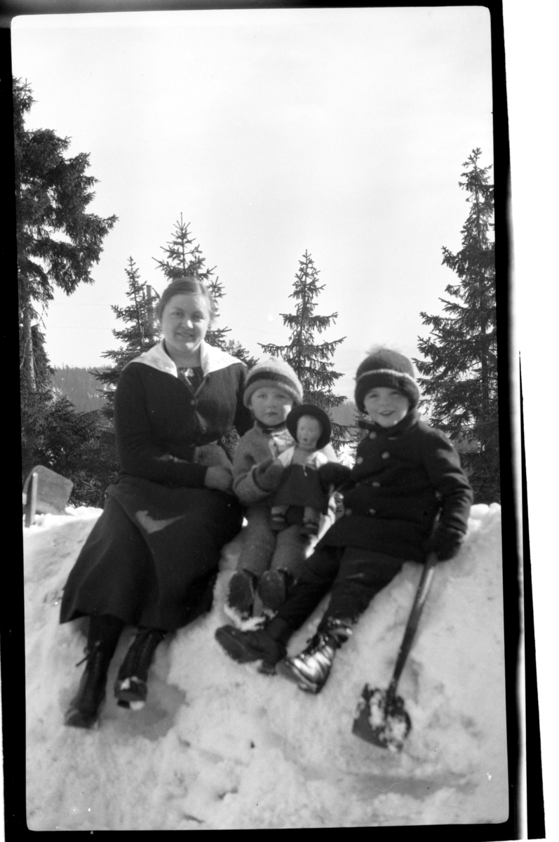 Rolf Sr. Sundt, Julius Sundt og Didrik Zernichow leker sammen med en ukjent dame i snøen, Villa Knyggen. Fotografert 1920.