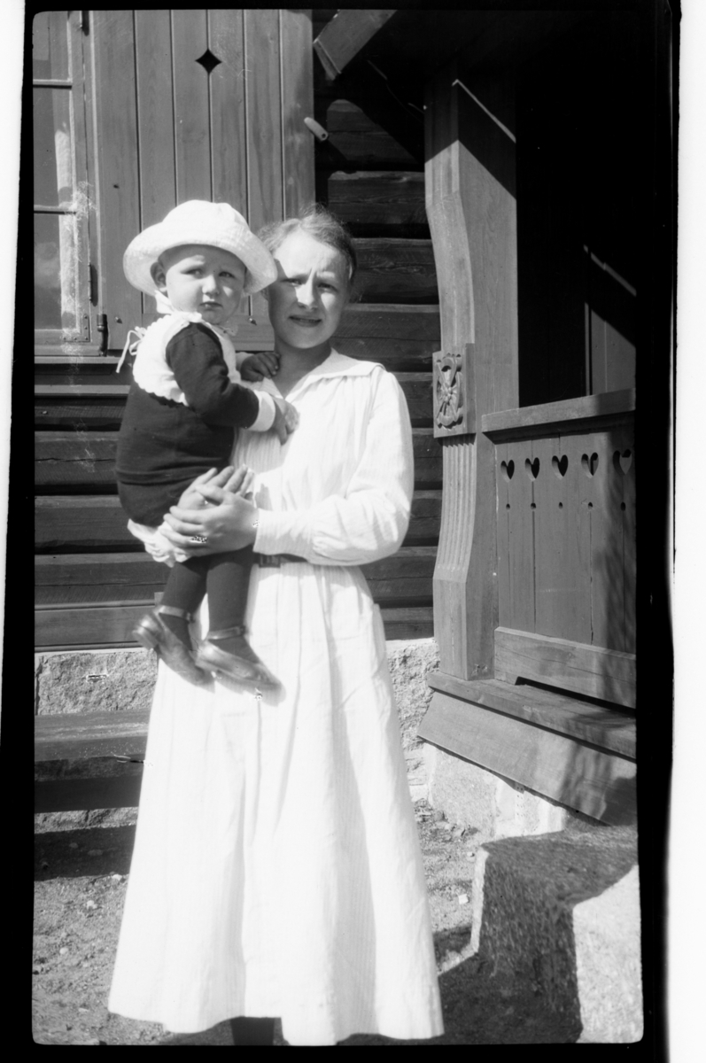 Rolf Sr. Sundt, Julius Sundt, ca. to år, sitter på armen til en barnepike, Villa Knyggen. Fotografert 1918-1919.