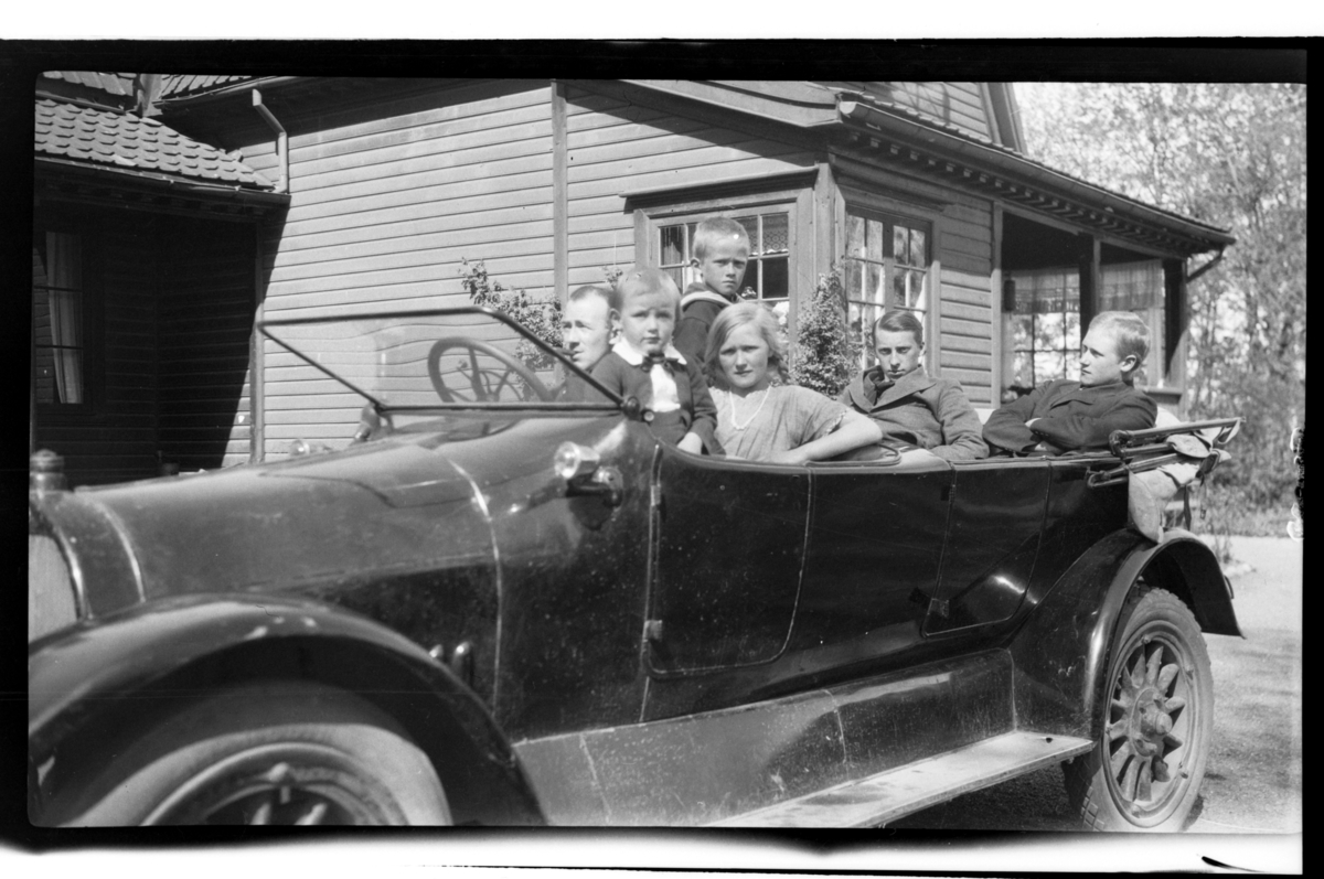 Rolf Sr. Sundt, En ukjent person, Julius Sundt, Bjarne Halfdannssøn Sundt, Julie Cecilie (Essemor) Sundt og to ukjente personer sitter i Rolf Sundts sr. Dodge, Stavern. Fotografert 1920.