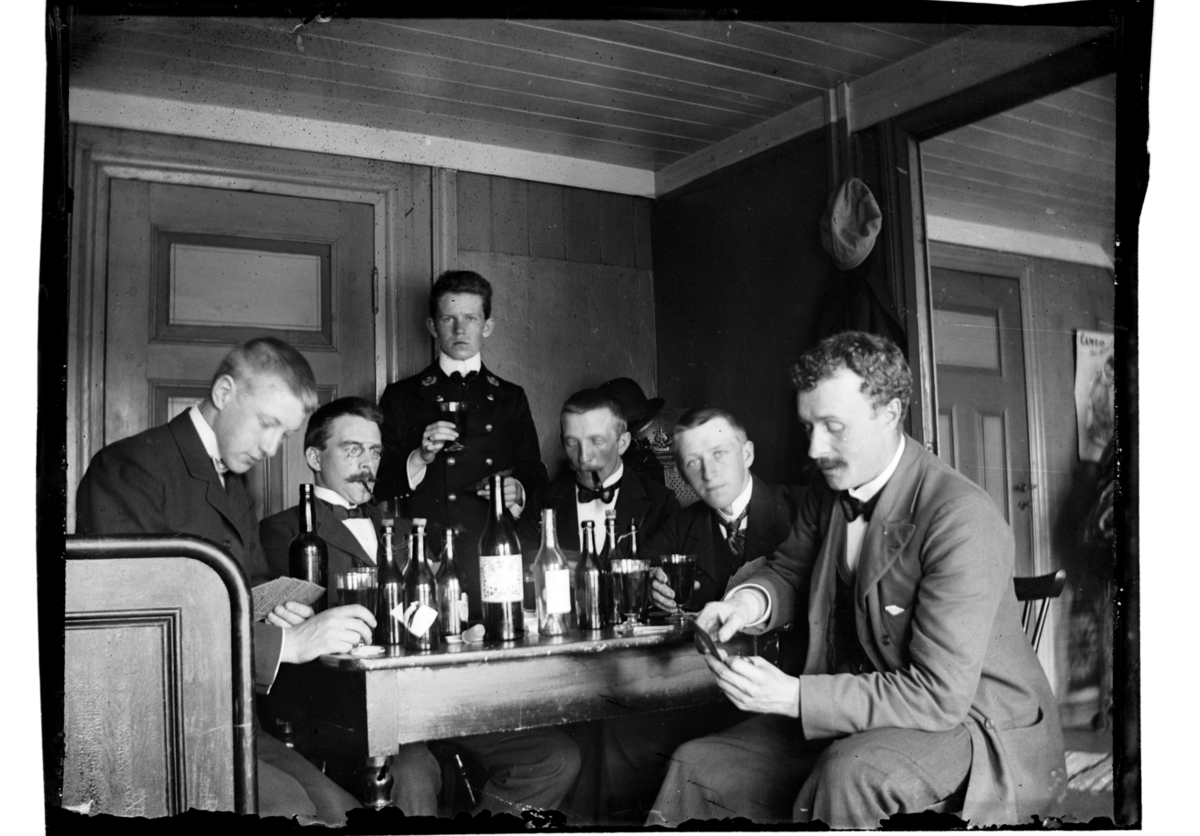 Rolf Sr. Sundt, Ant. Rolf Sundt sr. sitter som nr. to fra høyre sammen med flere menn rundet bord og spiller kort. Fotografert 1903-1904.