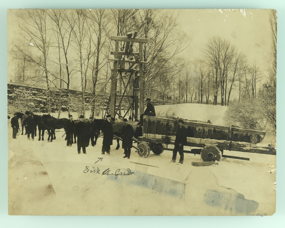 Anders Beer Wilse, Henrik Ibsens gravmonument (obelisk) transporteres til Vår Frelsers gravlund. Eirik A. Gude sammen med arbeidere.