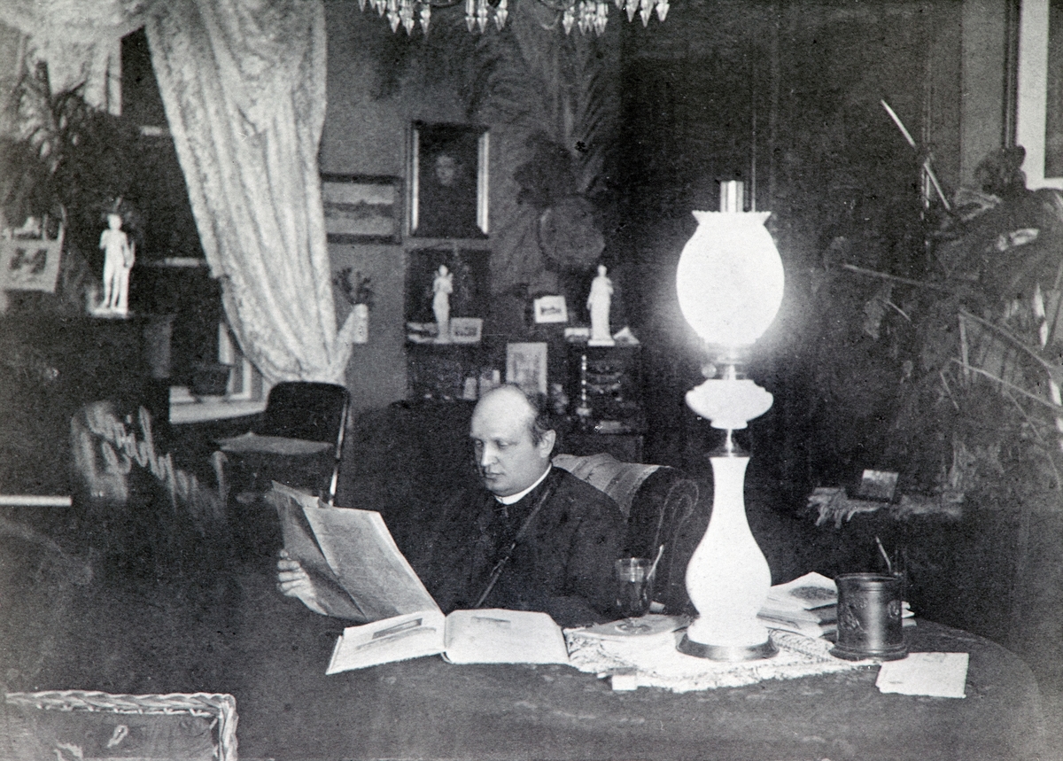 Anno Domkirkeodden, General Christian Wilhelm Engel Bredal Olssøn (1844-1915) leser. Interiør stue, parafinlampe. Hovelsrud, Helgøya.