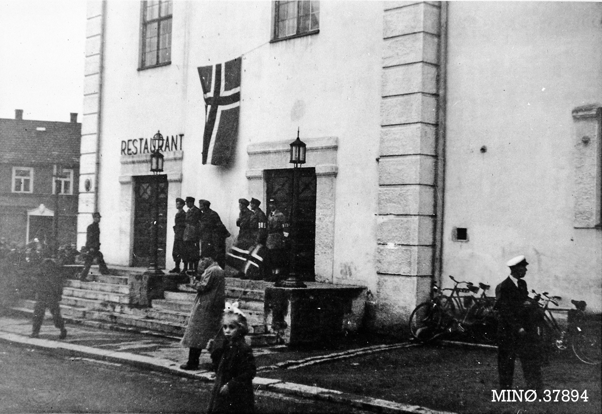 Oddvar Dobloug, Bygning med norsk flagg og mennesker utenfor