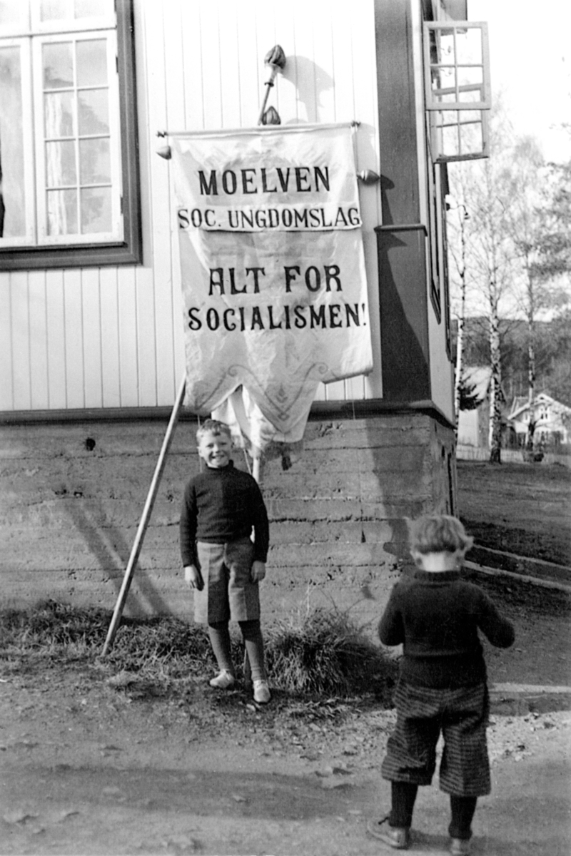 Anno Domkirkeodden, Folkets Hus, Moelv, 1936. Georg Svebakken foran fana til Moelven Socialistiske Ungdomslag med teksten "Alt for socialismen".