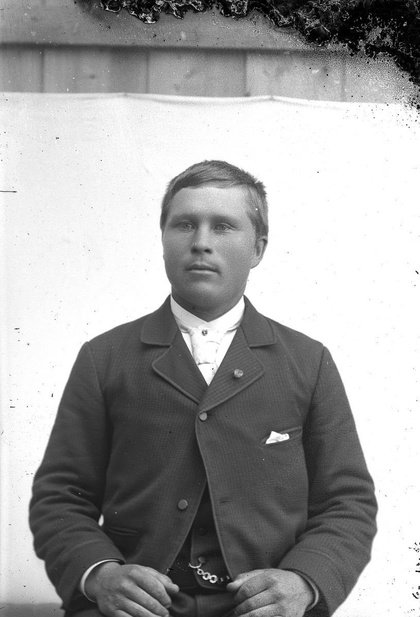 Jakob Jakobsen Engerdal, Ung mann med mørk dress, nål(?) på jakkeslaget, hvitt tørkle i brystlommen.