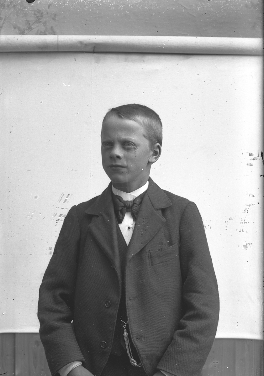 Jakob Jakobsen Engerdal, Ung gutt med mørk dress, sløyfe og klokkekjede.
