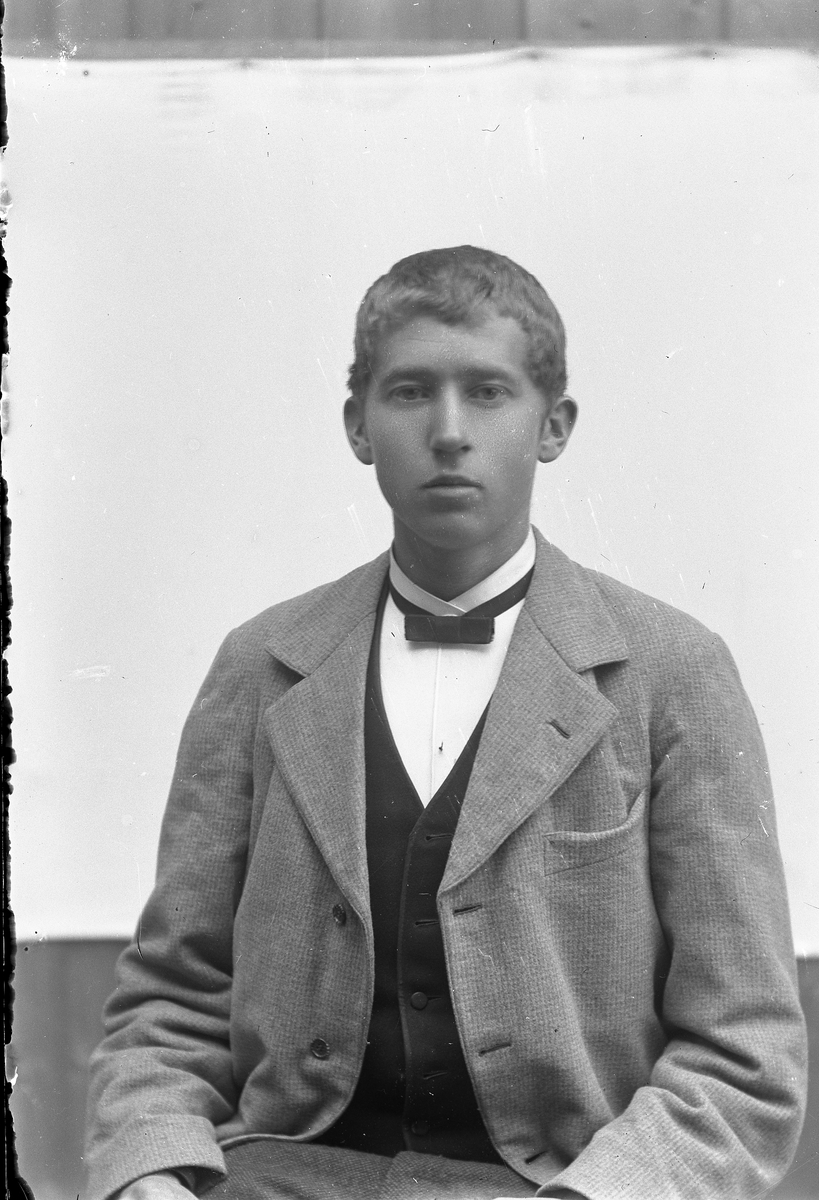 Jakob Jakobsen Engerdal, Portrett av ung mann med lys dress, mørk vest og sløyfe.