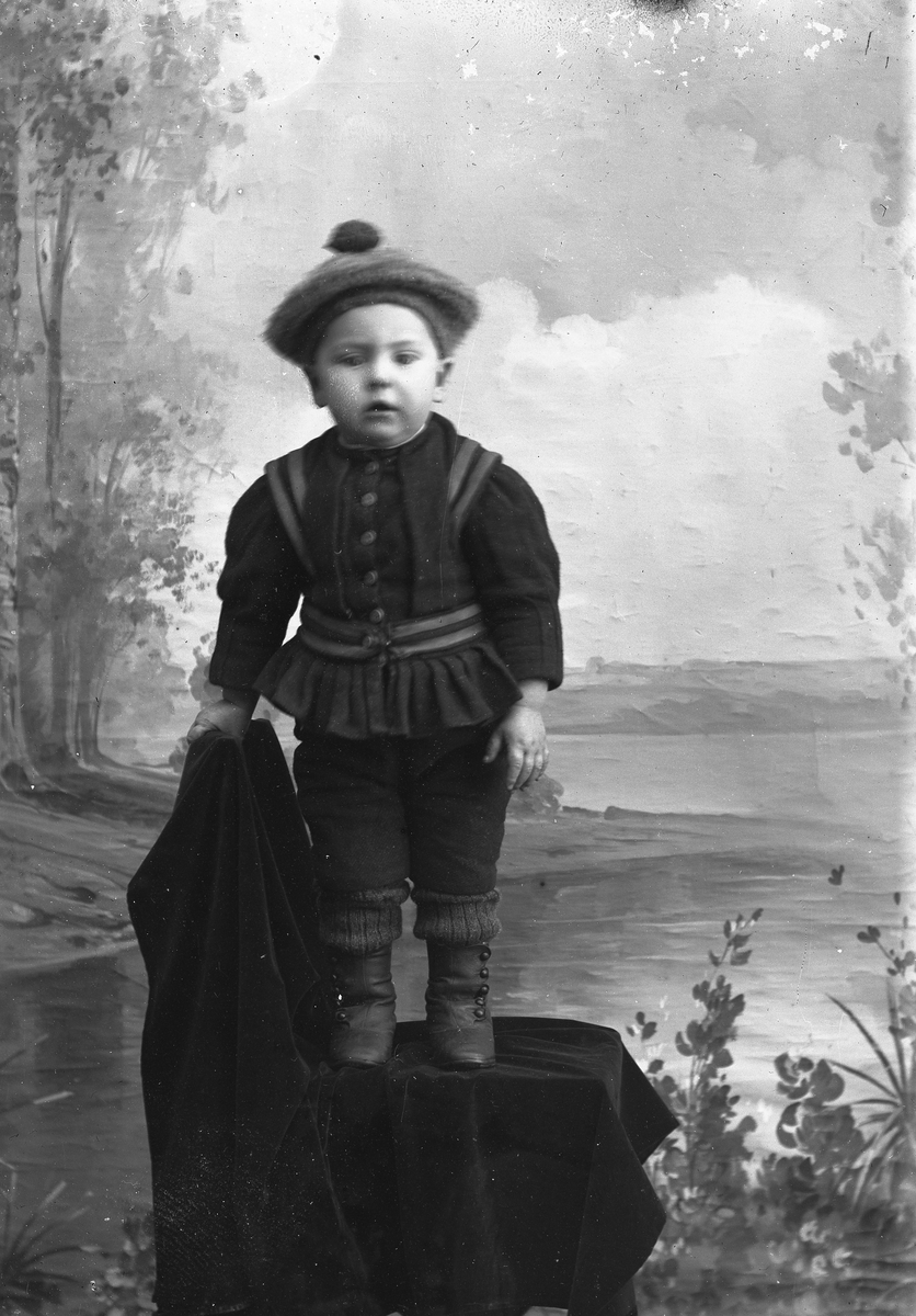 Jakob Jakobsen Engerdal, Liten gutt med lue og fin drakt. Står på en stol.