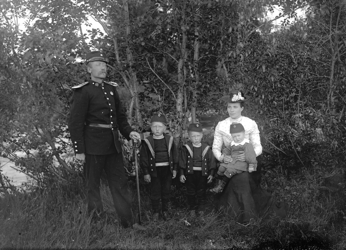 Jakob Jakobsen Engerdal, Sersjant og landhandler Halvor Halvorsen (1858-1947) med sin fru Karen Elise (f.1872-1958) og tre av barna deres; Harald Egil (f.1895), Aarfinn (f.1897) og Hjalmar (f.1898). Vi kan kanskje anta at bilde er tatt på eiendommen, Nyjordet, bygget 1898 for sersjant Halvor Halvorsen, som skulle drive la…
