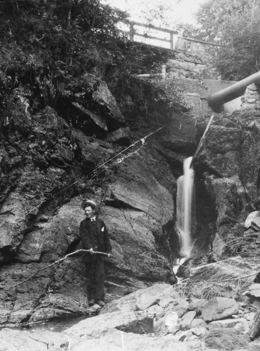 Ukjent, Østre Dystvoll (82/5). Dystvollfossen med liten vannføring. Rørledningen fører vatn til saga. Fisker, Harald Olstad, Flagstadelva.