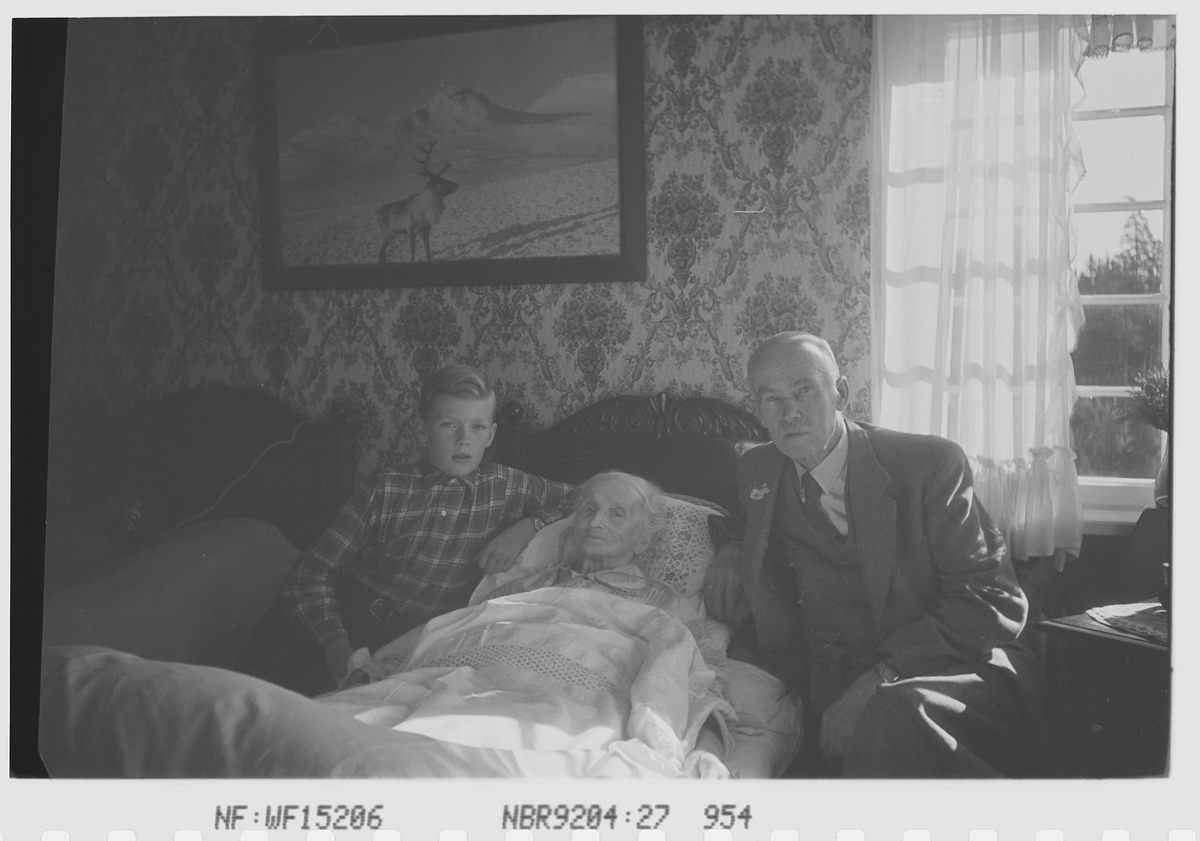 Anders Beer Wilse, Antatt Anders Beer Wilse sammen med sønnen Robert Charsel, og hustru Helen Marie Wilse født Hutchinson i sengen. Fotografi av reinsdyr på veggen. Fotografert 5.august 1941.