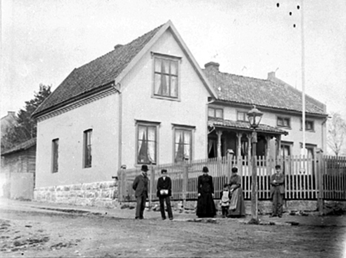 Anno Domkirkeodden, EKSTERIØR: HØIENSALGATE. 21 I HAMAR, OVERLÆRER JON RUD MED FAMILIE OG VENNER UTENFOR DERES HJEM. TIL VENSTRE: JON RUD, C. SCHIØTZ, (SENERE PROFESSOR I HYGIENE), LÆRERINNE V. HAUGEN, OLE BLEGEN RUD, (SENERE ALMENNINGSBESTYRER I VANG), FRU MARIE RUD, GÅRDEN BLE BYGGET I 1887.