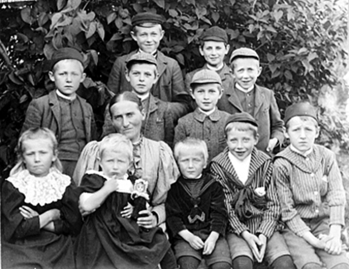 Anno Domkirkeodden, 11 barn og 1 voksen dame. Veterinær Gunnar Murstad, dr. Hjalmar Murstad, candjur. Otto Murstad, dir. Vilhelm Murstad, overlege Einar Murstad, bokhandler Halvor Erichsen, dr. Johs Erichsen, Ing. JensErichsen, fru Olga Eger. rektor Hans Henie - Agnethe fru Ragna. Navn bak på orginalen. Tidligere reg.…
