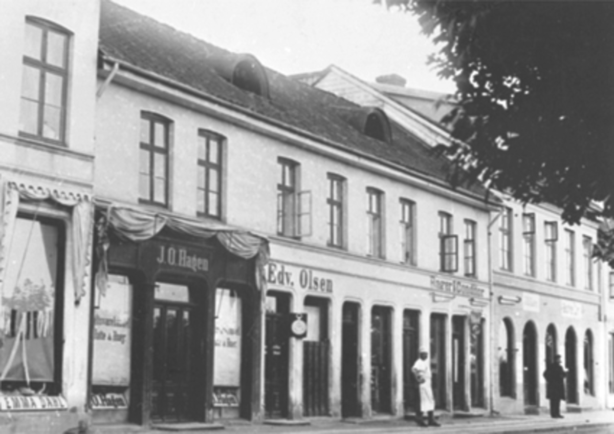 Anno Domkirkeodden, Eksteriør Strandgata 41-43. Forretningen til Emma Dahl, J. O Hagen, Edv. Olsen, Bager og Conditor B. Opsahl, skomaker J. O. Lier og søstrene Lier. Lengst til venstre bagermester B. Opsahl og mannen lenger bort i gaten skal være tannlege C. Opsahl.