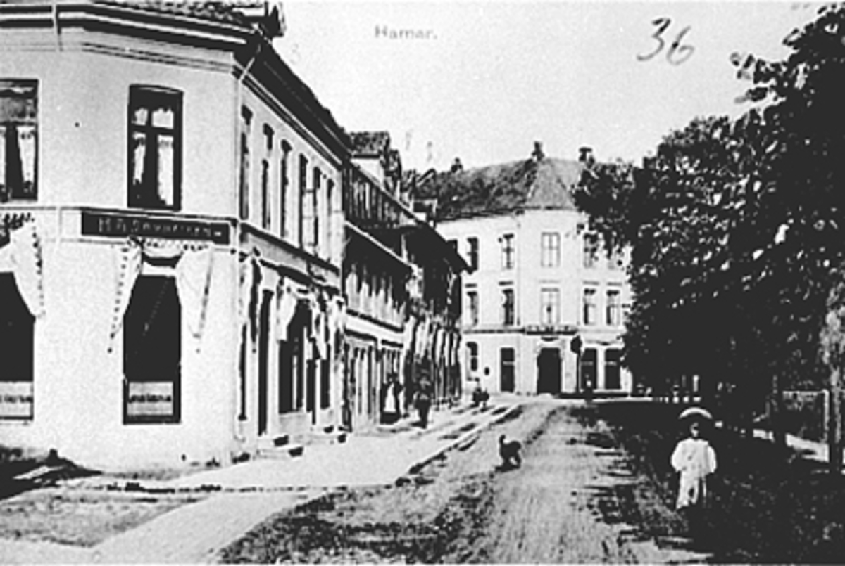 Anno Domkirkeodden, Oversikt fra Strandgata. 65 i Hamar, Lita jente, hund, folk. Bokhandel H. A. Samuelsens gård t. v ble bygget i 1859, fra 1872 til 1982 var det bokhandel her. Oplandske Kreditbank.