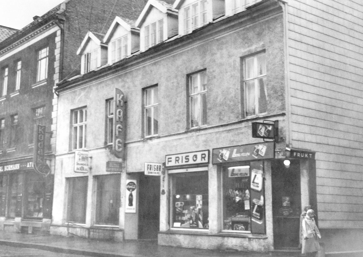 Anno Domkirkeodden, EKSTERIØR AV TORGGATA 13 FRA VENSTRE FOTOGRAF CARL NORMANNS FORRETNING, KAFE GLITNE, FRISØR OG FRUKT OG TOBAKKSFORRETNING MED SIGARETTREKLAME