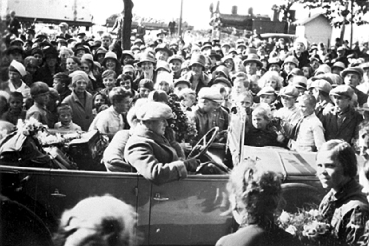 Anno Domkirkeodden, KRONPRINS OLAV OG KRONPRINSESSE MÂRTHA I ÅPEN BIL MED HØYRERATT REG. NR. A-458 SOM TILHØRTE H. K. H. KRONPRINSEN, FORAN FESTIVITETEN HAMAR, MYE FOLK, 1929.