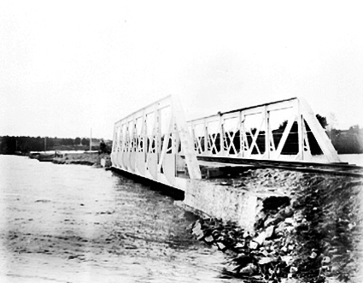 Anno Domkirkeodden, FLOMMEN I MJØSA 1895 VED JERNBANEBRUA PÅ ÅKERSVIKA, MANN MED DRESIN PÅ VENSTRE SIDE AV INNGANGEN TIL BRUA
