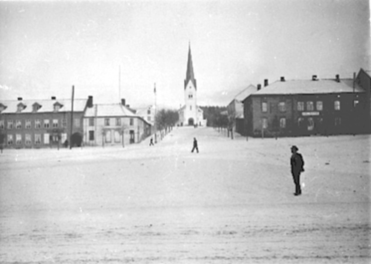 Anno Domkirkeodden, OVERSIKT FRA STORTORGET MOT TORGGATA FRA VENSTRE BAGERI, JOHN KRISTIANSEN SLAGTER OG PØLSEMAGER, HAMAR DOMKIRKE, HOTEL CENTRAL (MUNKEGÅRDEN), VINTER, NESTEN FOLKETOMT