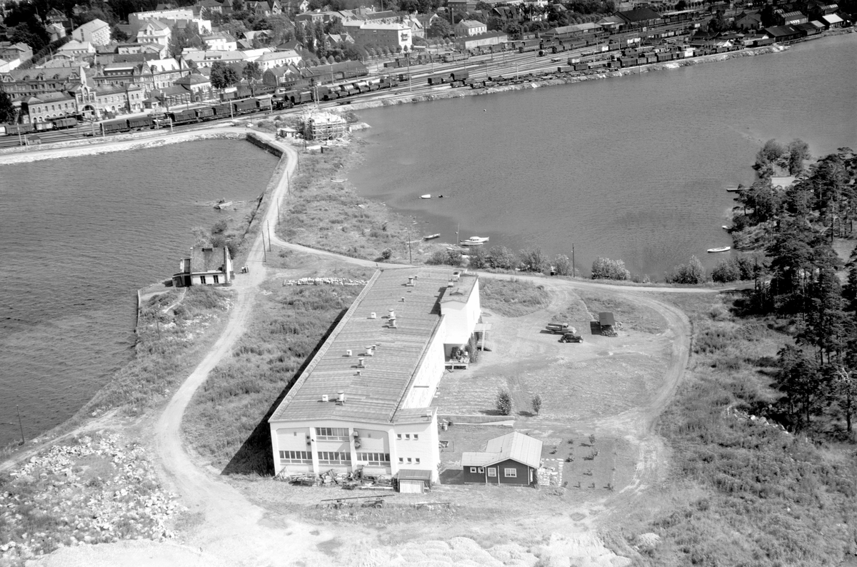 Widerøes Flyveselskap A/S, FLYFOTO O. KIRKEBYE & SØNNER LÆRFABRIKK, TJUVHOLMEN, HAMAR STASJON I BAKGRUNNEN