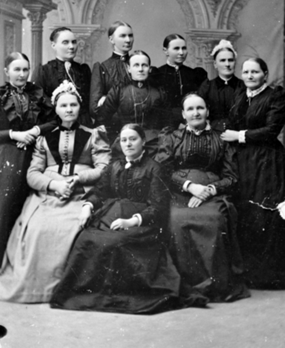 Anno Domkirkeodden, GRUPPE, 10 DAMER, STUDIO HOS FOTOGRAFEN Fra v. foran fru Opsahl g. m/tannlege Opsahl, fru Borgersen, fru Eriksen. Bak fra v. fru Lier, fru Solberg, fru Wilhelmsen g. m/byggm. Wilhelmsen, fru Hagen g. m/buntmaker Hagen, fru Jensen g. medkjøpmann G. Jensen, fru Andersen g. m/lærer Andersen, fru Jølst…