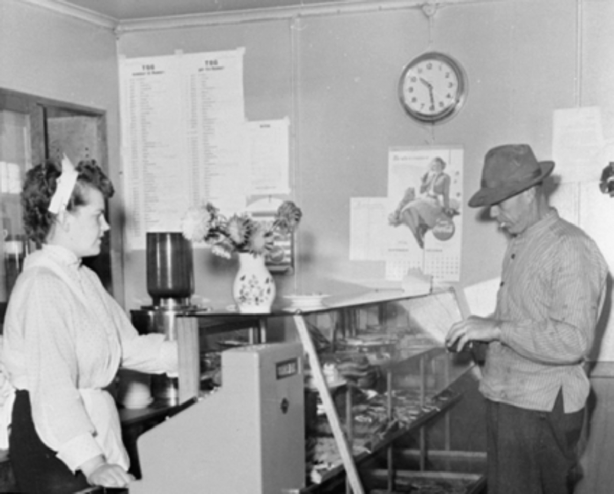 Anno Domkirkeodden, Centrum kafe, Grønnegata 41, Hamar. Interiør, kafedisk, kassaaparat., Ukjente. Dagmar Berge og Mathias Berge var vertskap. Etablert 1935. Serverte kaffe kaker, smørbrød og limonade.