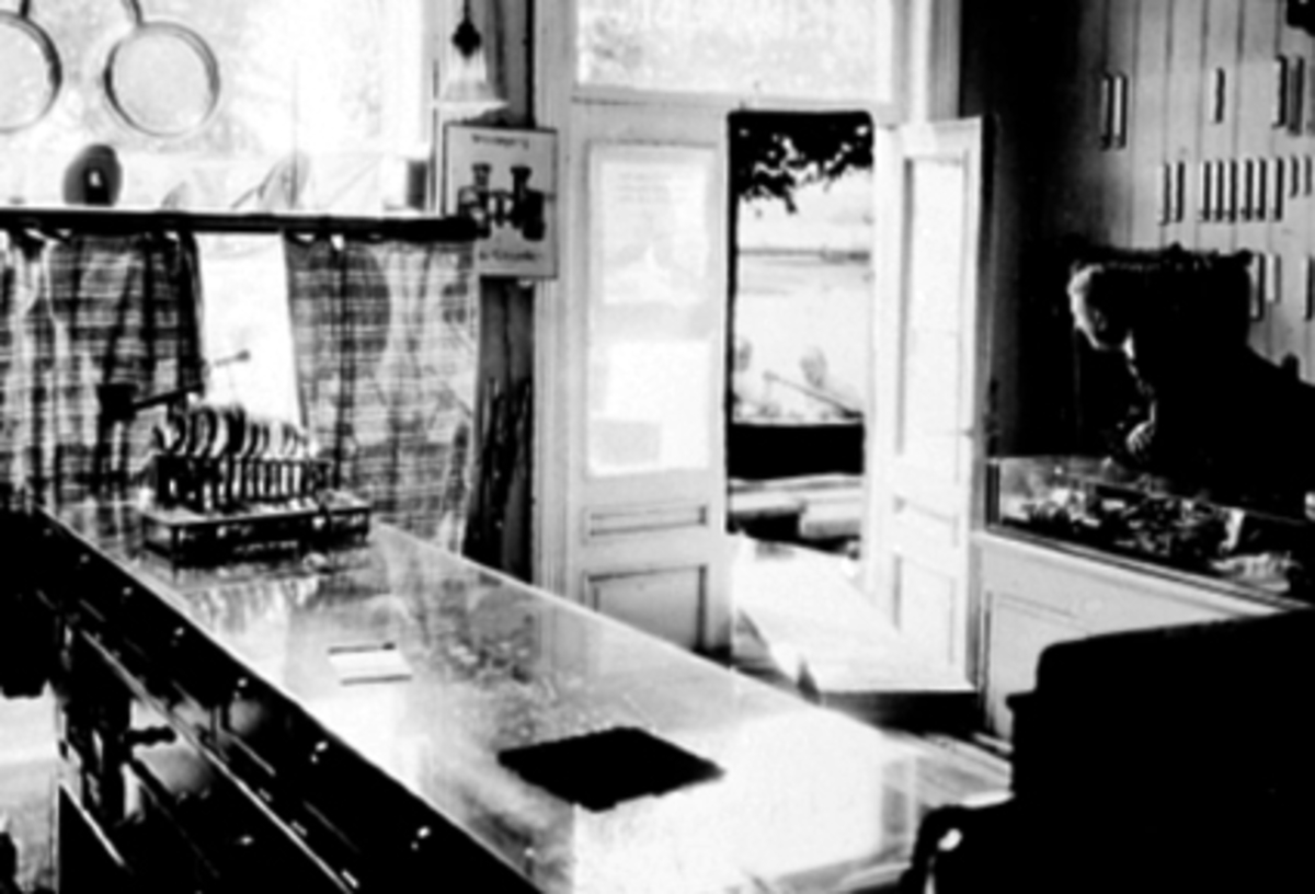 Anno Domkirkeodden, Trygve Hansen, E. Hammerstads eftf. interiør fra forretningen under storflommen i 1927. Trygve Hansen bak disken. Urmakerforretning. Mjøsflom.