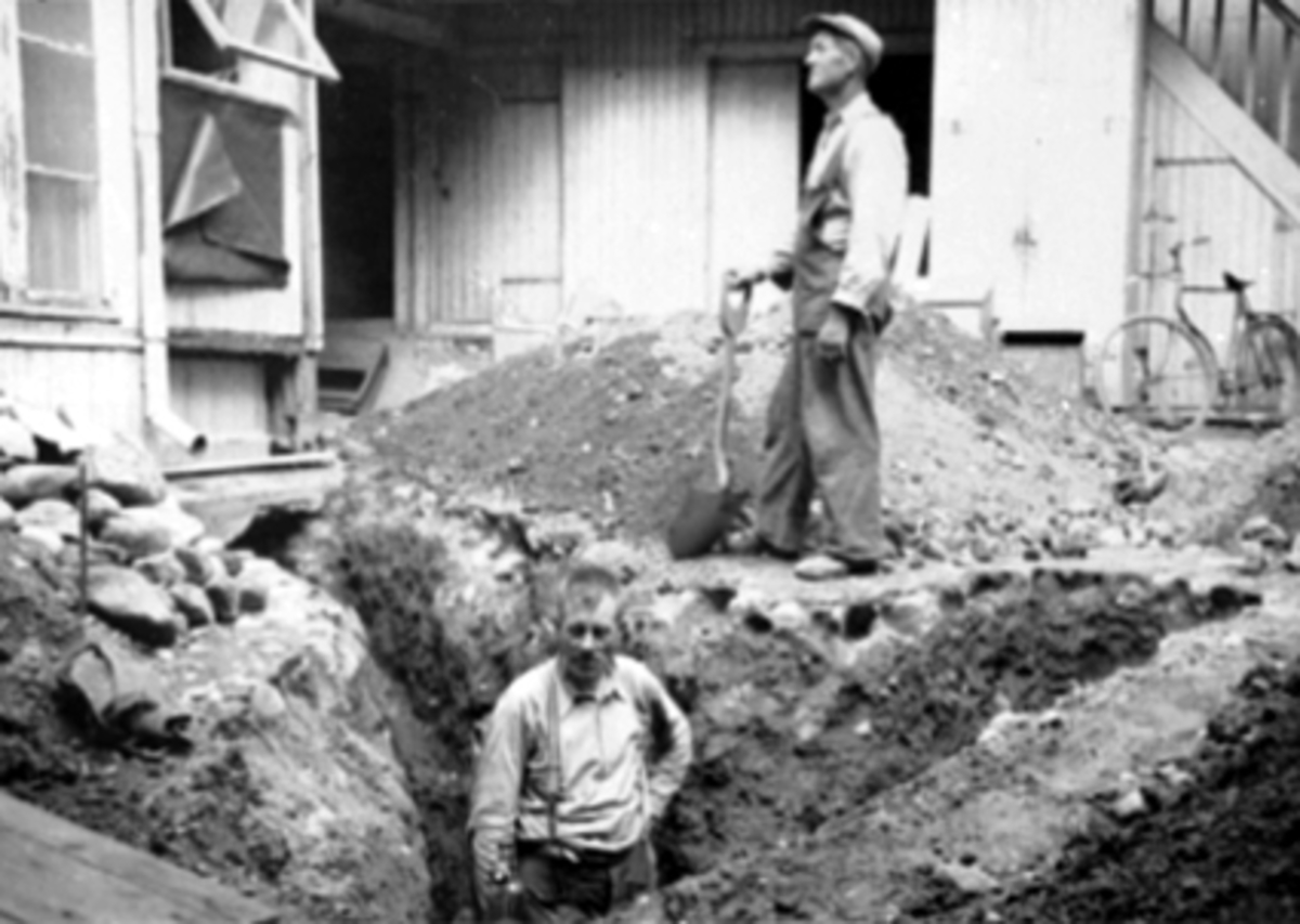 Anno Domkirkeodden, 2 MANN GRAVER GRØFT V/HUS, RØRLEGGING?, BAKGÅRD