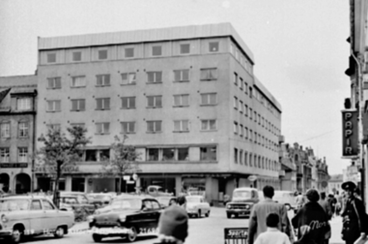 Anno Domkirkeodden, HOTELL ASTORIA, ØSTRE TORG, BILTRAFIKK, TORGGATA 23. Fra venstre: Trolig engelsk Ford Consul eller Zephyr mark II, som kom 1956, Opel Rekord 1953-57 (muligens med den store grillen som var spesiell for 1957) og mer i bakgrunnen en amerikansk Ford varebil (panel delivery) med de tre store tennene i …