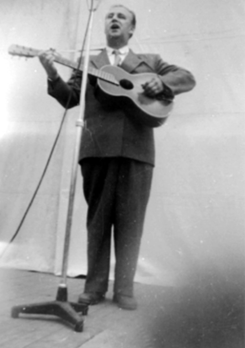 Anno Domkirkeodden, ALF PRØYSEN MED GITAR, MIKROFON, HAMARMARTEN PÅ UTSTILLINGSPLASSEN. Prøysen opptrådte under det radiooverførte showet, kalt "Show på Fesjå", ledet av Rolf Kirkvaag og Leif Rustad.