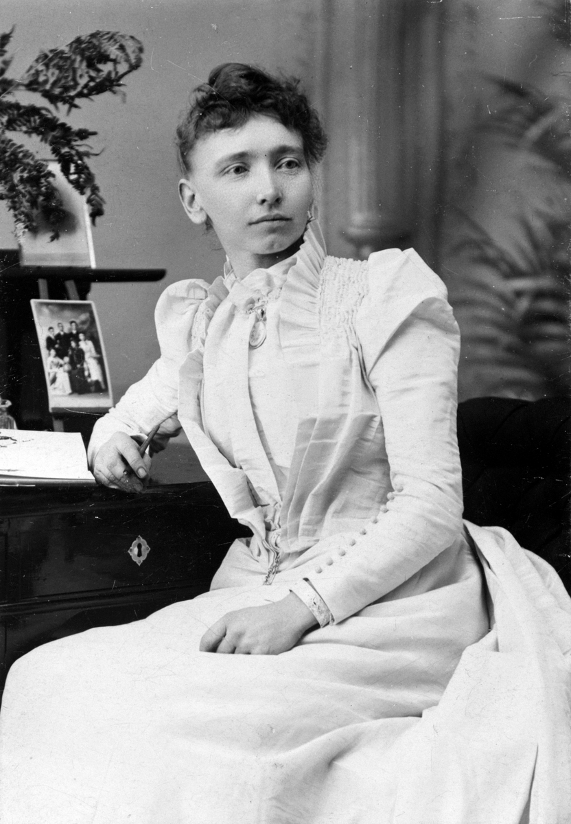 Anno Domkirkeodden, SELVPORTRETT FOTOGRAF RAGNHILDA ERIKSEN, 1862-1955, KVINNEKJOLE, KLÆR. Hun var utdannet fotograf og hadde gått i lære hos en av Kristianias første fotografer og i Tyskland. Hun drev fotoatelier i Vangsvegen 23 ved Østre torg, Hamar. Hun var også en aktiv politiker. Se årbok, utgitt av Hamar Histori…