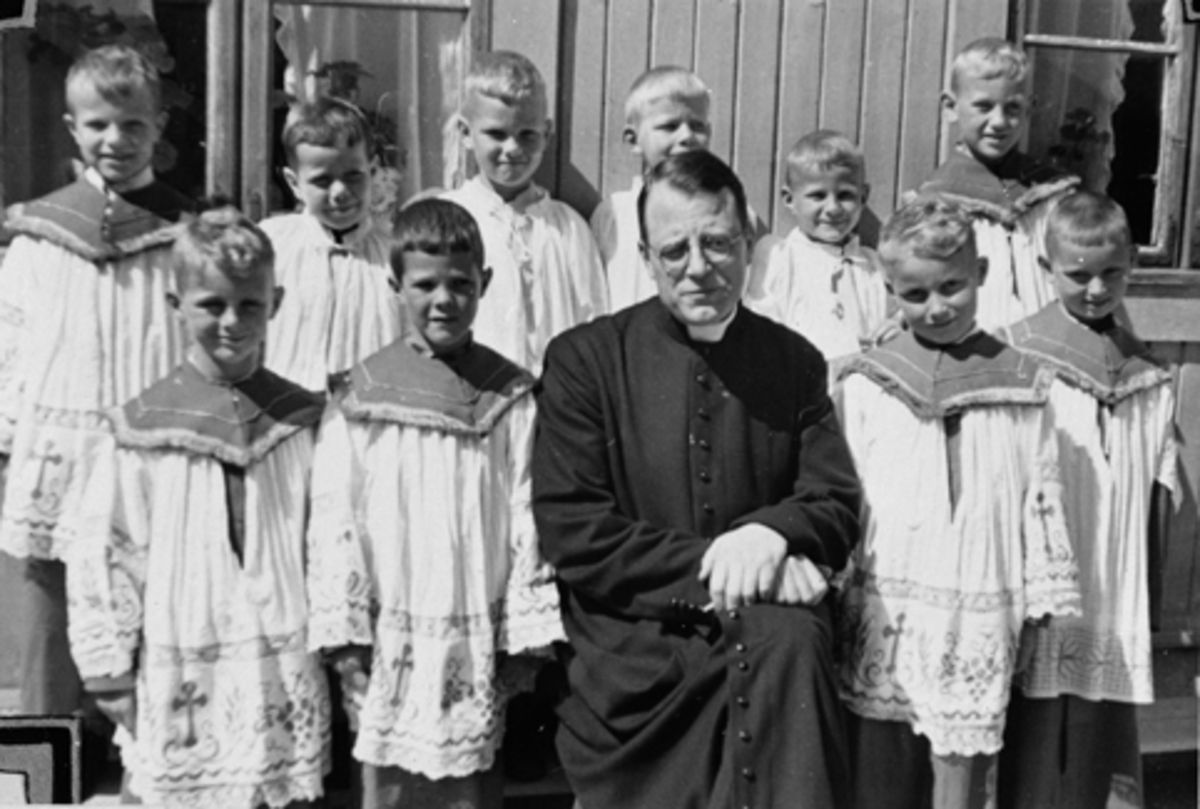 Anno Domkirkeodden, Pater Gustav de Paepe og gutter fra barnehagen ved feiringen av Kristi legemsfest i juni 1944. St. Torfinns barnehage, Hamar. Se årbok for Hedmarksmuseet/Hamar Historielag "Fra Kaupang og Bygd 2010"