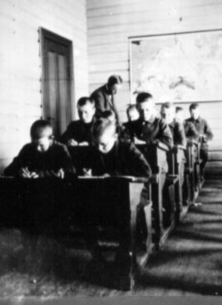 Anno Domkirkeodden, Interiør fra klasserom på Toftes Gave, Nedre Sund, Helgøya. Lærer underviser gutter som sitter ved 2-manns pulter.