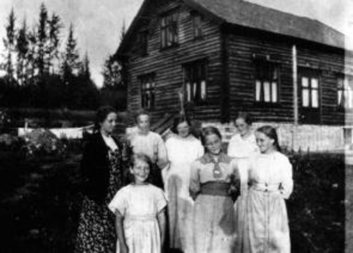 Anno Domkirkeodden, Gruppe damer og jenter foran huset i Furu (Mælingen), Helgøya.