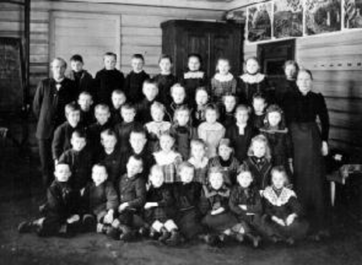 Anno Domkirkeodden, Stor gruppe skoleelever oppstillt utenfor Kirkekretsen skole, Veldre, Ringsaker. Lærere er Oline Rud og Johan Aarskog.