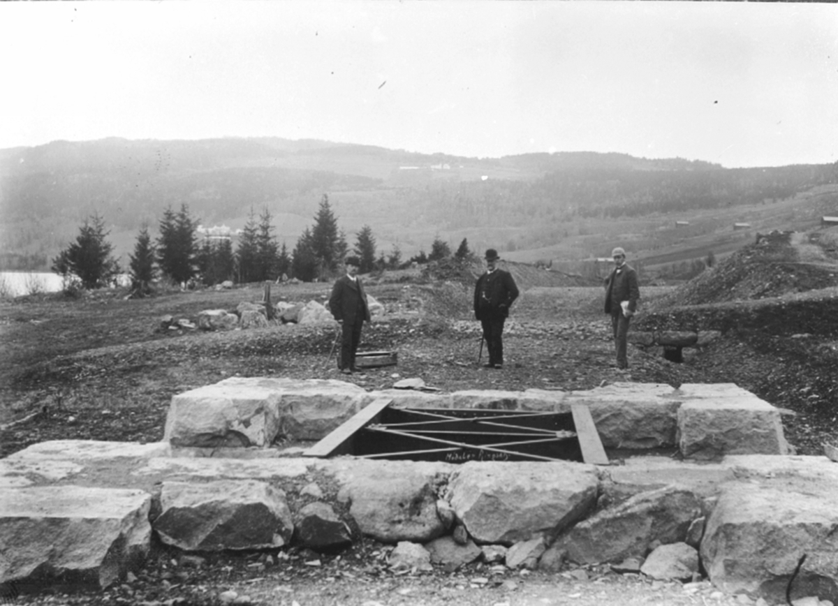 Anno Domkirkeodden, Jernbaneutbygging. Tre menn ved tørrmurt brufundament, vegundergang sør for Berg gård, Brøttum, Ringsaker.