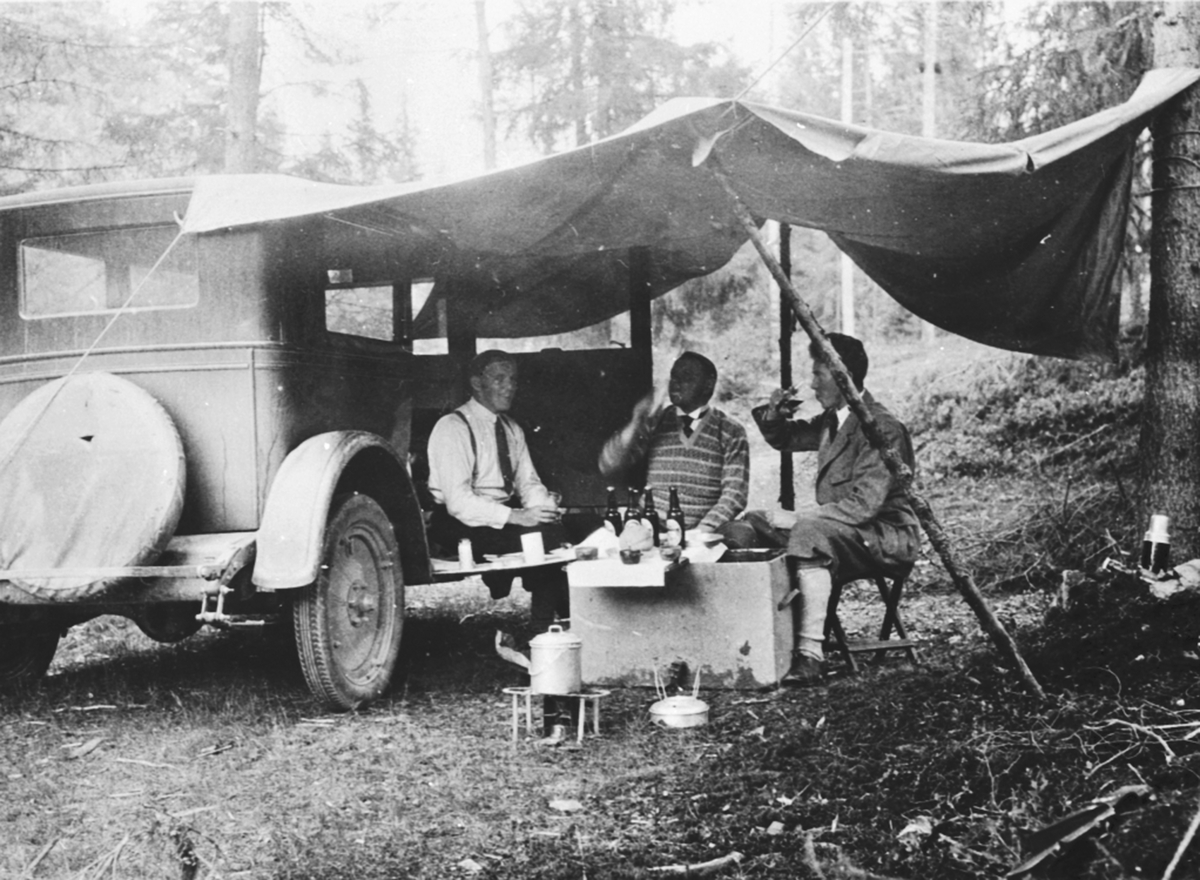 Anno Domkirkeodden, På utflukt, biltur med Chevrolet 1926 modell. Tre menn under presenning drikker øl. Fra venstre er tannlege Karl Løken, Nickelsen, Bjørnerud.