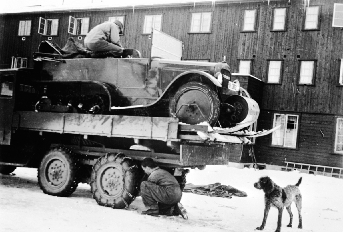 Anno Domkirkeodden, Beltebil Citroen A-1303 skal fraktes til fjells med lastebil. Mann setter på kjettinger.