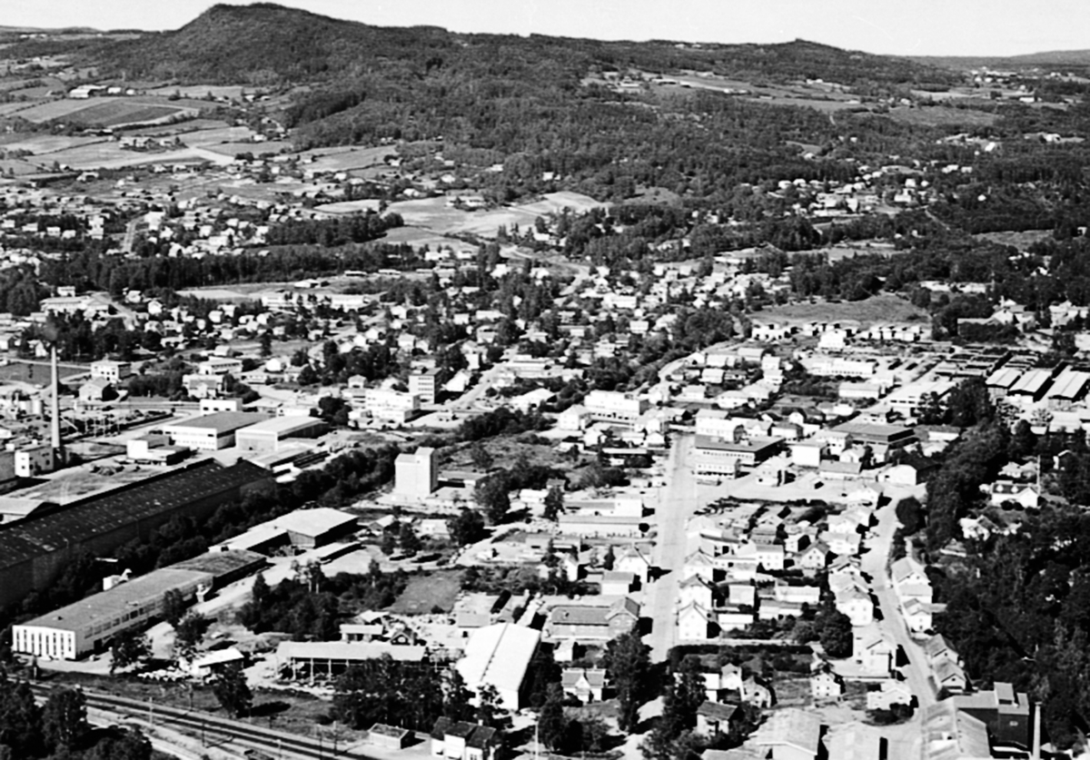 Anno Domkirkeodden, Flyfoto, Brumunddal sentrum, bebyggelsen i Gamlegata og Nygata. Berger Langmoen A/S med Langmopipa til venstre.