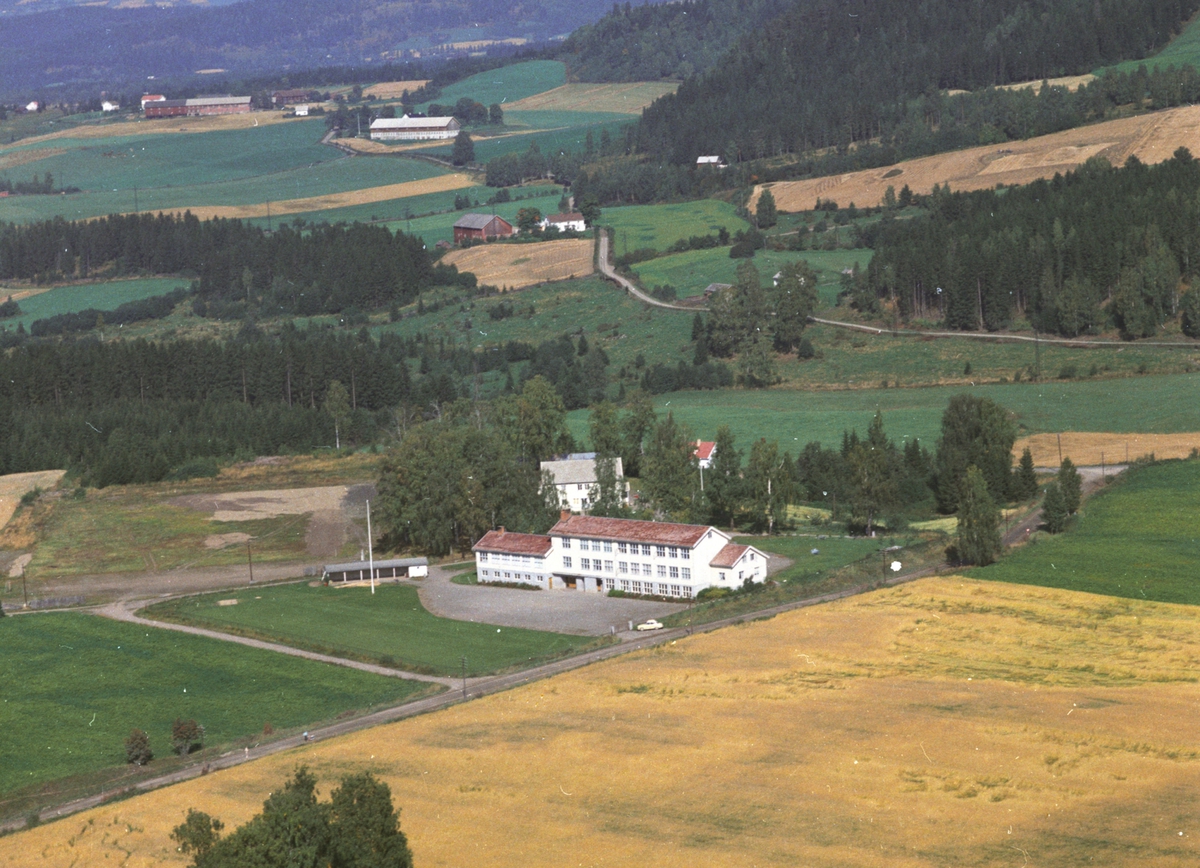 Widerøes Flyveselskap A/S, Flyfoto av Saugstad skole, Gaupen., Ringsaker. Ungdomshjemmet bak skolen(nærmest) Gårdene bak er først Lillemæhlum, store Mæhlum og Nyhus bakerst.