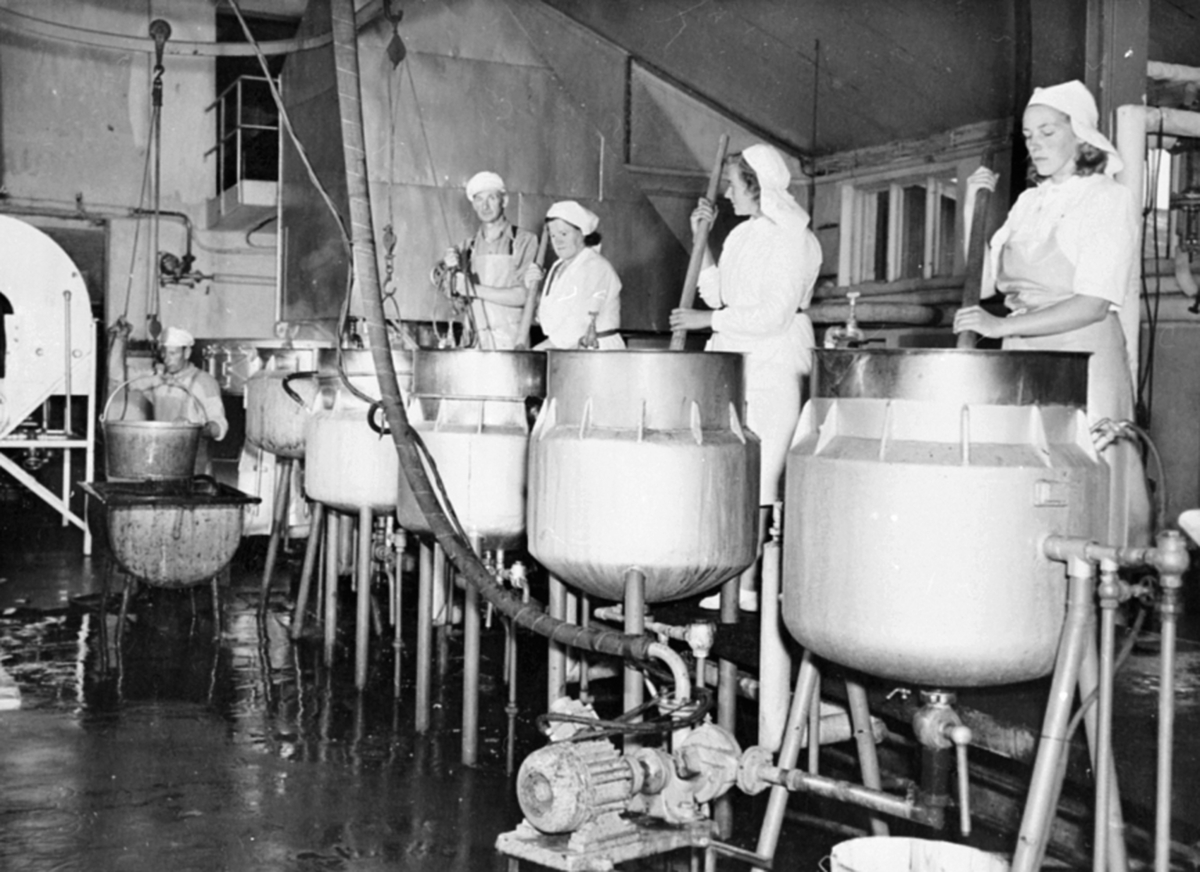 Anno Domkirkeodden, Interiør på A/S Oplandske Konservesfabrikk, Stabburet, Nora. Brumunddal. Fem arbeidere ved kokebatteri. Fra venstre er Bernhard Johansen, Odvin Nilsen, Rigmor Høivåg, Lilly Olsen, Borghild Gresby.