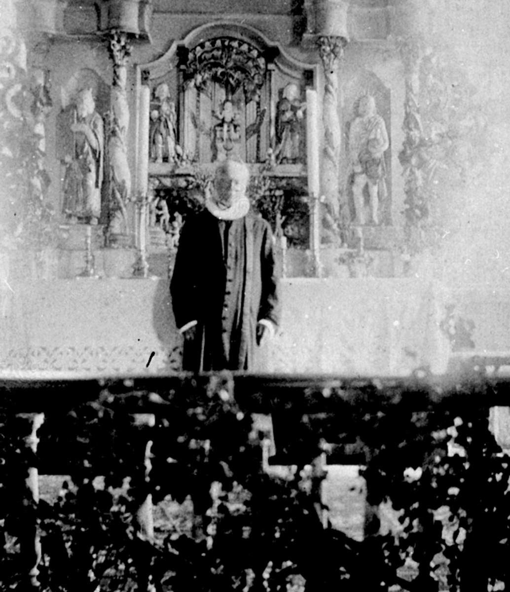 Anno Domkirkeodden, Pastor Reinert Svendsen foran altertavle i Veldre kirke, Ringsaker.