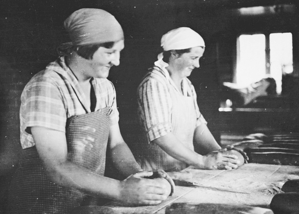 Anno Domkirkeodden, 2 damer baker. Kokka på Flisaker gard, Veldre, Ringsaker og yngste datter til Joergis elter deig.