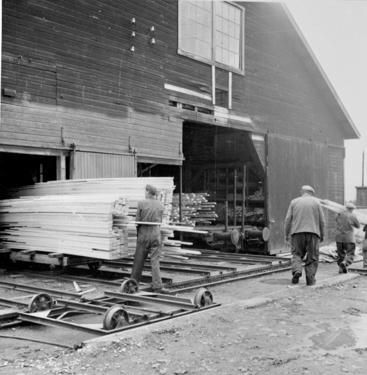 Anno Domkirkeodden, Menn arbeider på høvellastlageret, materialer på jernbanevogner, Berger Langmoen A/S, Brumunddal.