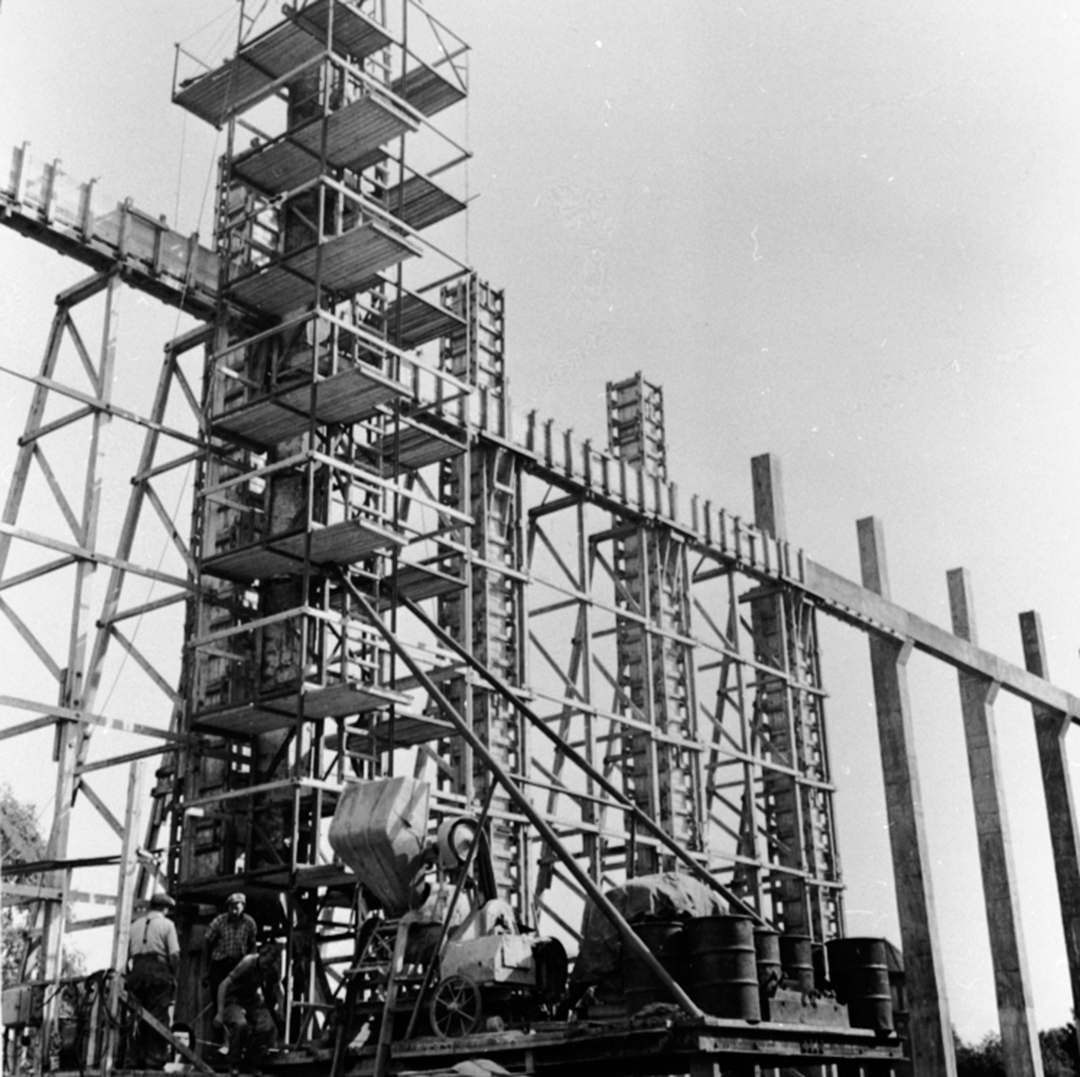 Anno Domkirkeodden, Anleggsarbeid, bygging av materiallager langs Brumunda, forskaling, stillaser, sementblander, 3 menn arbeider, Berger Langmoen A/S, Brumunddal.