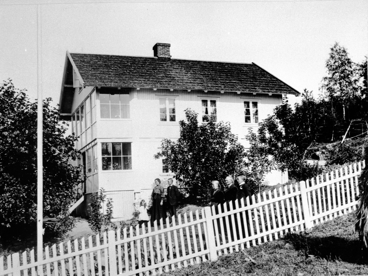 Anno Domkirkeodden, Gruppe personer foran huset Olstad ved Nordheim, Ring, Ringsaker.